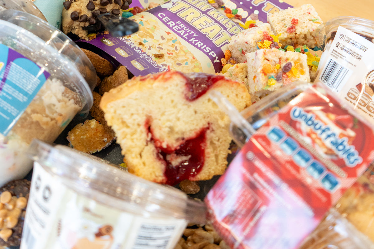A variety of Buffin Bakery desserts including a jam-filled muffin, fruity cereal krispy treats, and packaged protein snacks.