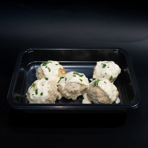 Keto Ricotta Meatballs: Five low carb meatballs in creamy white sauce, garnished with parsley, served in a sleek black container against a dark background—delicious and keto-friendly.