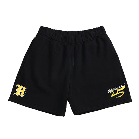 Spring Club Shorts - Yellow (Limited Stock) feature an elastic waistband, athletic fit, a bold yellow H on the left leg, and Athletic Club 25 text on the right. Ideal for gym sessions or everyday wear.