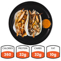 Savor Baja Chicken Tacos—two flavorful chicken tacos served on a black plate with zesty sauce. Each serving has 360 calories, 32g protein, 32g carbs, and 10g fat—ideal for meal prep or a healthy dinner option.