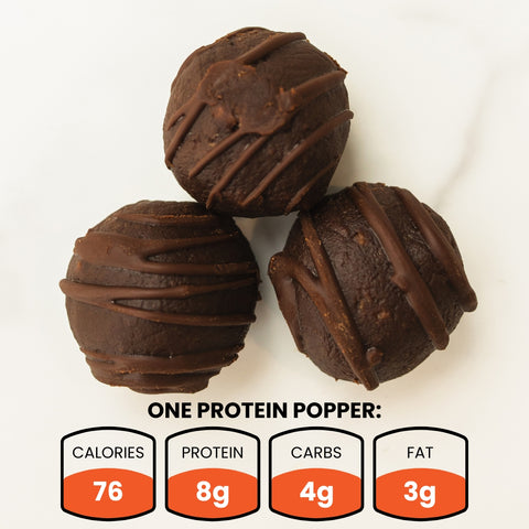 Three Banana Chocolate Protein Poppers (Subscription) are arranged on a white surface—a tasty, protein-packed snack. Each popper has 76 calories, 8g protein, 4g carbs, and 3g fat for healthy snacking.