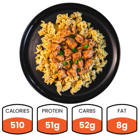 The BBQ Chicken Mac Bowl features rotini pasta and grilled chicken, garnished with herbs. This healthy meal has 510 calories, 51g protein, 52g carbs, and 8g fat—ideal for meal prep.