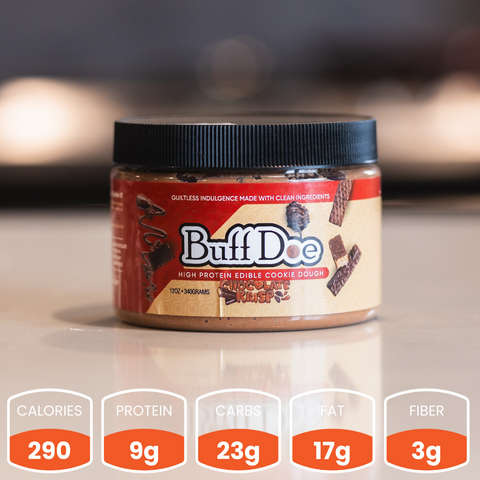 A jar of Buffdoe Chocolate Krisp (Subscription) protein edible cookie dough sits on the counter. Each serving has 290 calories, 9g protein, 23g carbs, 17g fat, and 3g fiber—a delicious way to fuel your day!.