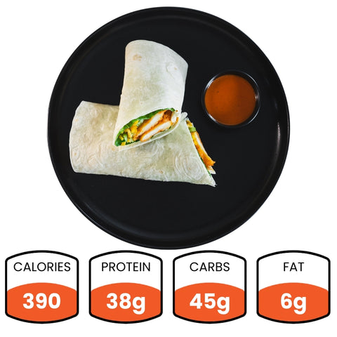 The Buffalo Crispy Chicken Wrap, cut in half on a black plate with fat-free ranch, packs 390 calories, 38g protein, 45g carbs, and 6g fat—making it a healthy meal prep option.