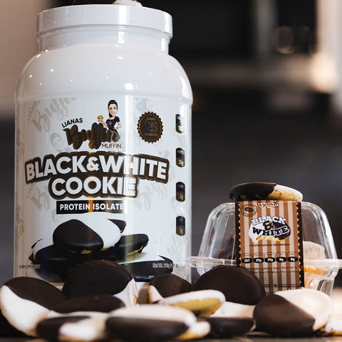 A large white container labeled Lianas Buffin Muffin - Protein Isolate sits next to a small plastic package with a black and white cookie inside, displaying whey protein cookies for dessert-inspired flavors in front.