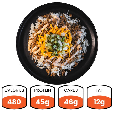 The Cheeseburger Bowl features rice, ground meat, cheddar cheese, pickles, and sauce for a tasty meal. Nutrition: 480 calories, 45g protein, 46g carbs, and 12g fat—ideal for healthy meal prep.