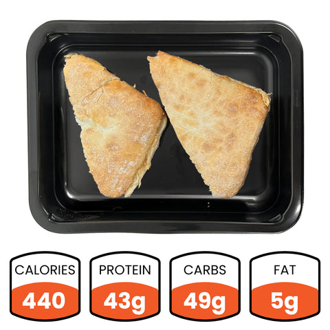 Chicken Ciabatta: Two triangular grilled chicken sandwich halves on ciabatta bread served on a black tray. Nutrition facts—440 calories, 43g protein, 49g carbs, and 5g fat—make it perfect for a gourmet lunch.
