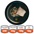 The Grilled Chicken Pesto Wrap, served on a black plate, offers 410 calories, 41g protein, 32g carbs, and 12g fat—ideal for meal preppers wanting a tasty and nutritious boost.