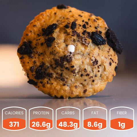 A close-up of a Buffin Muffin topped with chocolate bits—a tasty, protein-rich snack for on the go: 371 calories, 26.6g protein, 48.3g carbs, 8.6g fat, and 1g fiber.