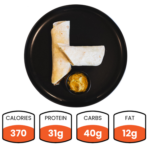 The Crispy Vegan Wrap is served on a black plate with a dip, offering 370 calories, 31g protein and fiber, 40g carbs, and 12g fat—a perfect healthy lunch choice.
