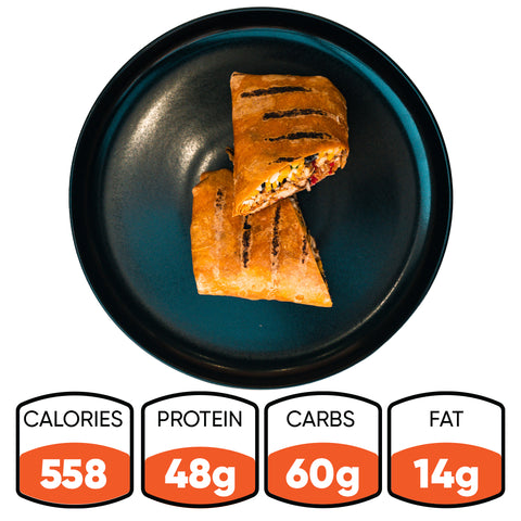 The Hey Arnold Burrito is a grilled, high-protein chicken wrap cut in half and served on a black plate. It has 558 calories, 48g protein, 60g carbs, and 14g fat—ideal for refueling after a workout.
