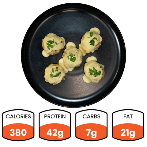 Five Keto Ricotta Meatballs made with ground chicken are topped with cheese and herbs on a black plate. Nutritional info: 380 calories, 42g protein, 7g net carbs, and 21g fat.