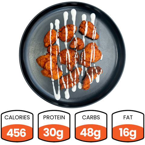 A black plate with buffalo-style chicken pieces drizzled with white sauce. Below, nutrition facts show: 456 calories, 30g protein, 48g carbs, and 16g fat.
