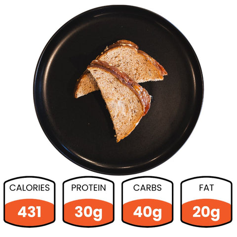 A Peanut Butter & Jelly Sandwich on a black plate, sliced in half, with nutrition facts below: 431 calories, 30g protein, 40g carbs, and 20g fat—an ideal workout snack.