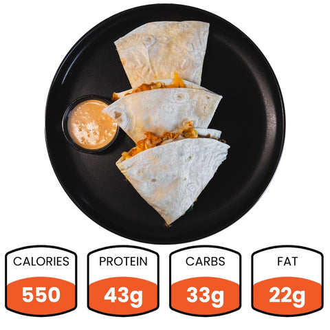 Three slices of Southwest Chicken Quesadilla with chipotle sauce on a black plate, pictured from above. Nutrition: 550 calories, 43g protein, 33g carbs, and 22g fat—making it a healthy meal prep option.
