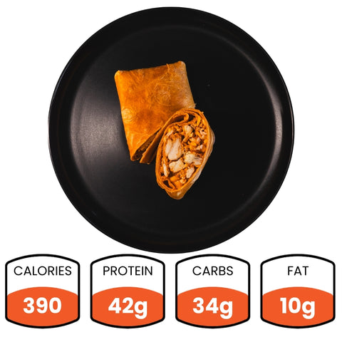 A black plate displays a cut Spicy Buffalo Wrap with chicken filling—ideal for healthy wraps or meal prep. Nutrition facts: 390 calories, 42g protein, 34g carbs, and 10g fat.