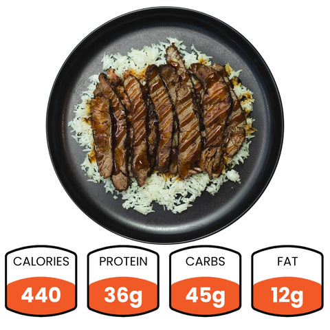 A black plate holds sliced steak over white rice with sauce—this Teriyaki Flank Bowl (Subscription) is ideal for meal prep. Nutrition below: 440 calories, 36g protein, 45g carbs, and 12g fat.
