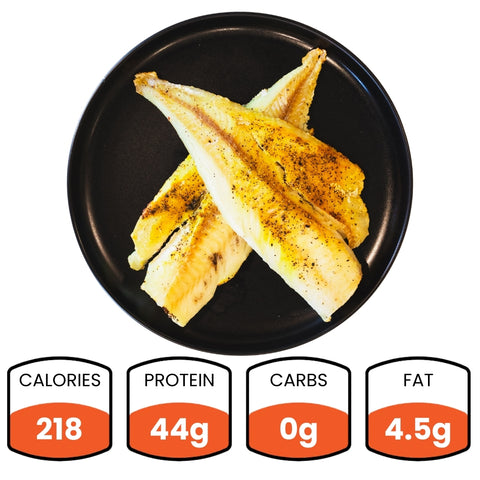 Baked Herbed Tilapia (1lb Competition Approved) fillets on a black plate, seasoned with pepper. Each serving contains 218 calories, 44g protein, 0g carbs, and 4.5g fat—ideal for weight loss and meal prep.