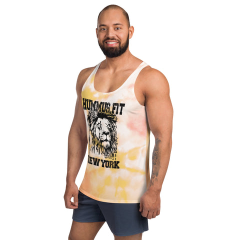 A smiling bearded man wears the Pink & Gold Tank Top, featuring a lion graphic and “HUMMUS.FIT NEW YORK” text, paired with dark shorts against a white background.