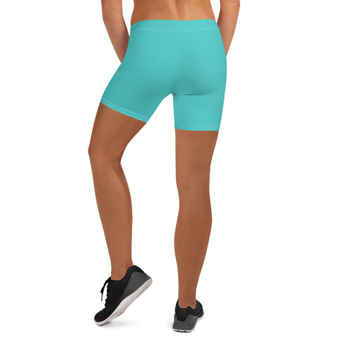 A person faces away from the camera, wearing Womens Turquoise Shorts with a comfy elastic waistband and black athletic shoes, set against a white background.