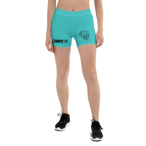 A person wearing Womens Turquoise Shorts with a comfy elastic waistband and MUMMYS FIT bear graphic on the left side stands against a plain white background. Black sneakers are also visible.