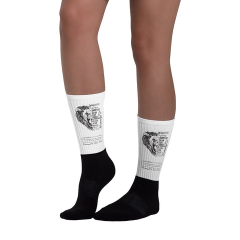 Someone wearing Sacrifice Worldwide Socks, featuring knee-high white uppers with a lion graphic and text, plus black foot and ankle sections, stands against a white background.