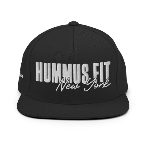 The Black Snapback Hat features embroidered white HUMMUS FIT New York text in bold and cursive on the front, and an adjustable snapback closure for comfort.