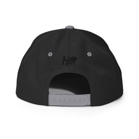 The Black & Silver Snapback Hat showcases a gray adjustable strap and H FIT embroidered above the opening, combining classic snapback style with modern comfort.