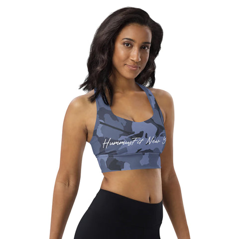 A woman with shoulder-length dark hair models the Blue Camo Sports Bra and black leggings against a plain white background.