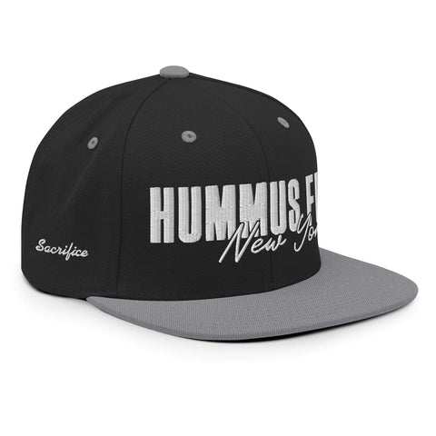 The Black & Silver Snapback Hat features a classic fit in black and gray with HUMMUS.FIT New York in white embroidery on the front and Sacrifice script on the side. This adjustable hat guarantees a comfortable, perfect fit.
