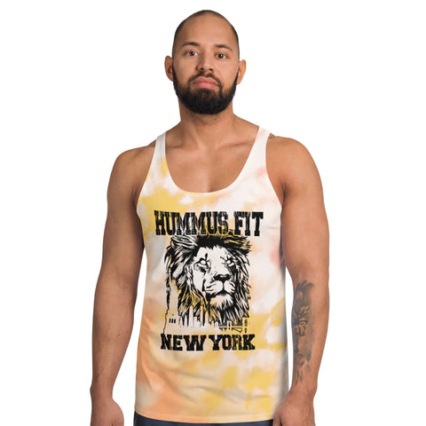A bearded man stands facing forward against a plain white background, wearing a relaxed fit Pink & Gold Tank Top with vibrant tie-dye colors, a lion’s head graphic, and the text Hummus Fit New York.