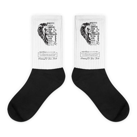 The Sacrifice Worldwide Socks are soft, cushioned crew socks in white and black, featuring a detailed lion face and motivational text about sacrifice and hard work on the upper part.