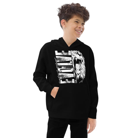 A smiling boy with curly hair wears the Unisex Kids Fleece Hoodie in black, featuring a roaring lion graphic and bold white ELITE text, standing with one hand in his pocket against a plain white background.