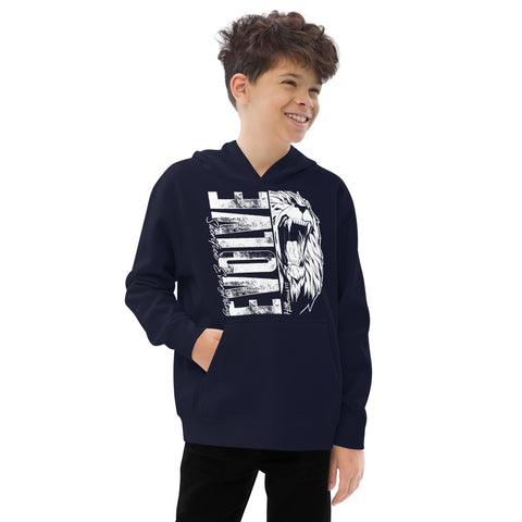 A smiling boy with short, curly hair stands with hands in pockets, wearing the Unisex Kids Fleece Hoodie featuring a soft fleece design and a bold white roaring lion graphic with the word ELITE on the front.