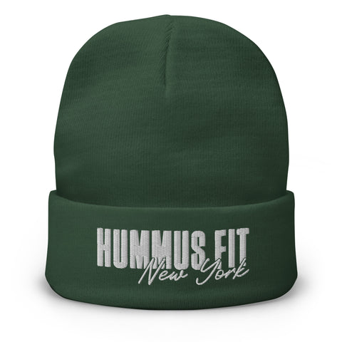 The Hummus Fit NY Embroidered Beanie is a dark green cotton blend beanie featuring HUMMUS FIT New York stitched in white on the front fold.