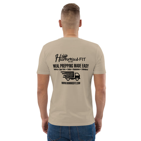 A man faces away, wearing a beige Unisex Hummus Fit New York Desert Dust T-Shirt with “Meal Prepping Made Easy,” a delivery truck graphic, and www.hummusfit.com on the back.