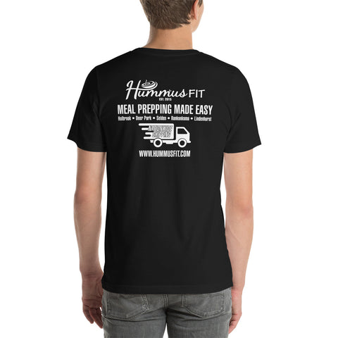 Someone wears a comfortable gold Unisex Hummus Fit T-Shirt made from soft cotton, featuring Hummus Fit Meal Prepping Made Easy, a delivery truck graphic, website URL, and locations printed on the back.