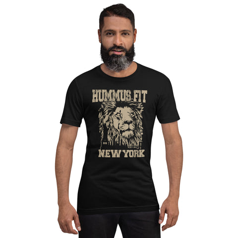 A bearded man wears a Unisex Hummus Fit New York Black T-Shirt with a bold beige lions face graphic, standing against a plain white background.