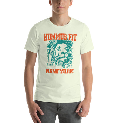 A person wears the Unisex Hummus Fit New York Citron T-Shirt, a comfy white 100% cotton tee featuring an illustrated lion’s face and bold orange and teal “HUMMUS FIT NEW YORK” text.