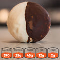 A round snack coated half in white chocolate and half in dark chocolate sits on a smooth surface. Below, nutrition facts list: 390 calories, 25g protein, 45g carbs, 12g fat, and 2g fiber.
