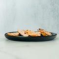 Three folded quesadillas featuring healthy grilled chicken and visible melted cheese are arranged on a dark plate, set on a light-colored marble surface with a soft gray background. The delicious HFit Signature Fold is perfect for grilled chicken meal prep or an easy anytime meal.