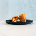 A black plate displays the Spicy Buffalo Wrap, cut in half to reveal its shredded meat filling. Set on a white marble surface with a light gray background, this scene is perfect inspiration for healthy wraps and meal prep ideas.