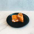 A black plate holds the Spicy Buffalo Wrap, sliced in half to showcase its seasoned chicken filling. Ideal for meal prep, the wrap is presented on a white marble surface with a light gray background.