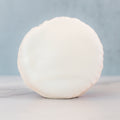 The Red, White Blue Buffin Muffin, a high-protein treat coated in smooth white chocolate, stands upright on light marble with a soft blue background.