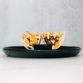 Baja Chicken Tacos feature grilled chicken, shredded cheddar, and mozzarella cheese in low-carb flour tortillas, served on a black plate with dipping sauce at the center, set against a light gray background.