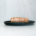 A single The Arches Mac Daddy Wrap sits on a dark plate against a light background, perfect for crafting a macro-friendly lunch or assembling a high-protein meal prep wrap.