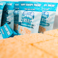 Multiple Buff Krispy Treat packages are arranged upright, showcasing the Original Krispy flavor. A close-up reveals a large protein snack and visible Best By date stickers, making Buff Krispy Treat an appealing choice for muscle recovery.