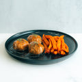 Bourbon Turkey Meatballs served on a sleek black plate with herbs and sweet potato fries, set against a light background—the perfect high-protein meal prep option.
