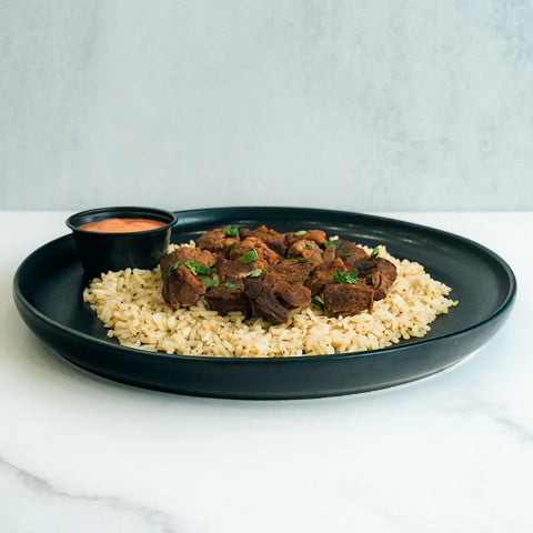 Enjoy “GLORIOUS GAINS” Steak Bites Cilantro Lime Rice—a high-protein meal featuring seasoned cilantro lime rice, tender steak bites, fresh herbs, and a zesty orange dipping sauce, ideal for nutritious meal prep.