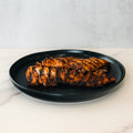 Chipotle Chicken 1lb Competition Approved features sliced, pre-cooked grilled chicken breast with char marks, arranged on a black plate—ideal for meal prep or healthy dinners.